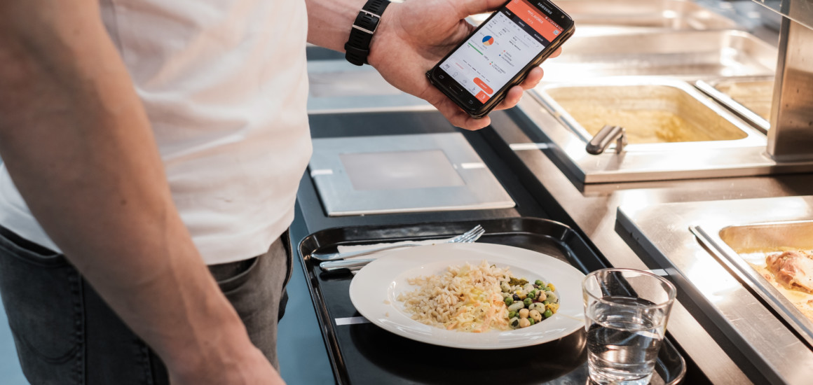 Käyttäjä katsoo ruokalinjastolla valitsemansa ruoan tietoja mobiilipalvelusta.