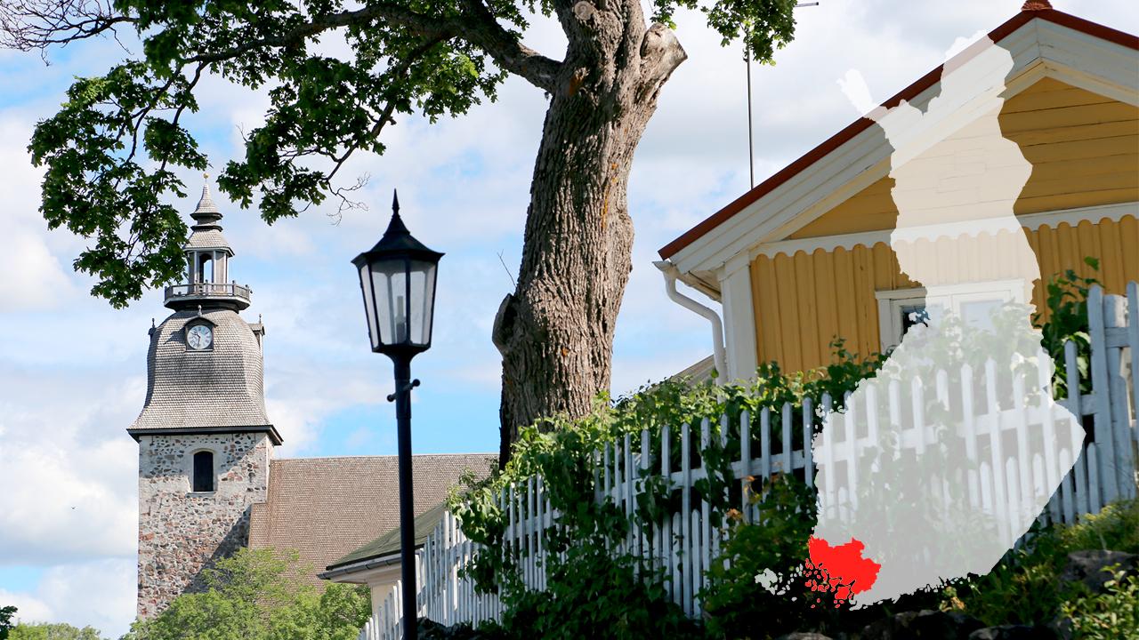 Maisema jossa vasemmalla Naantaliln kirkon torni, katulamppu, iso puu ja keltainen puutalo. Oikealla Suomen kartta, josta korostettu punaisella Varsinais-Suomen maakunta.