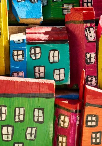 Värikkäitä puupaloista askarreltuja taloja.