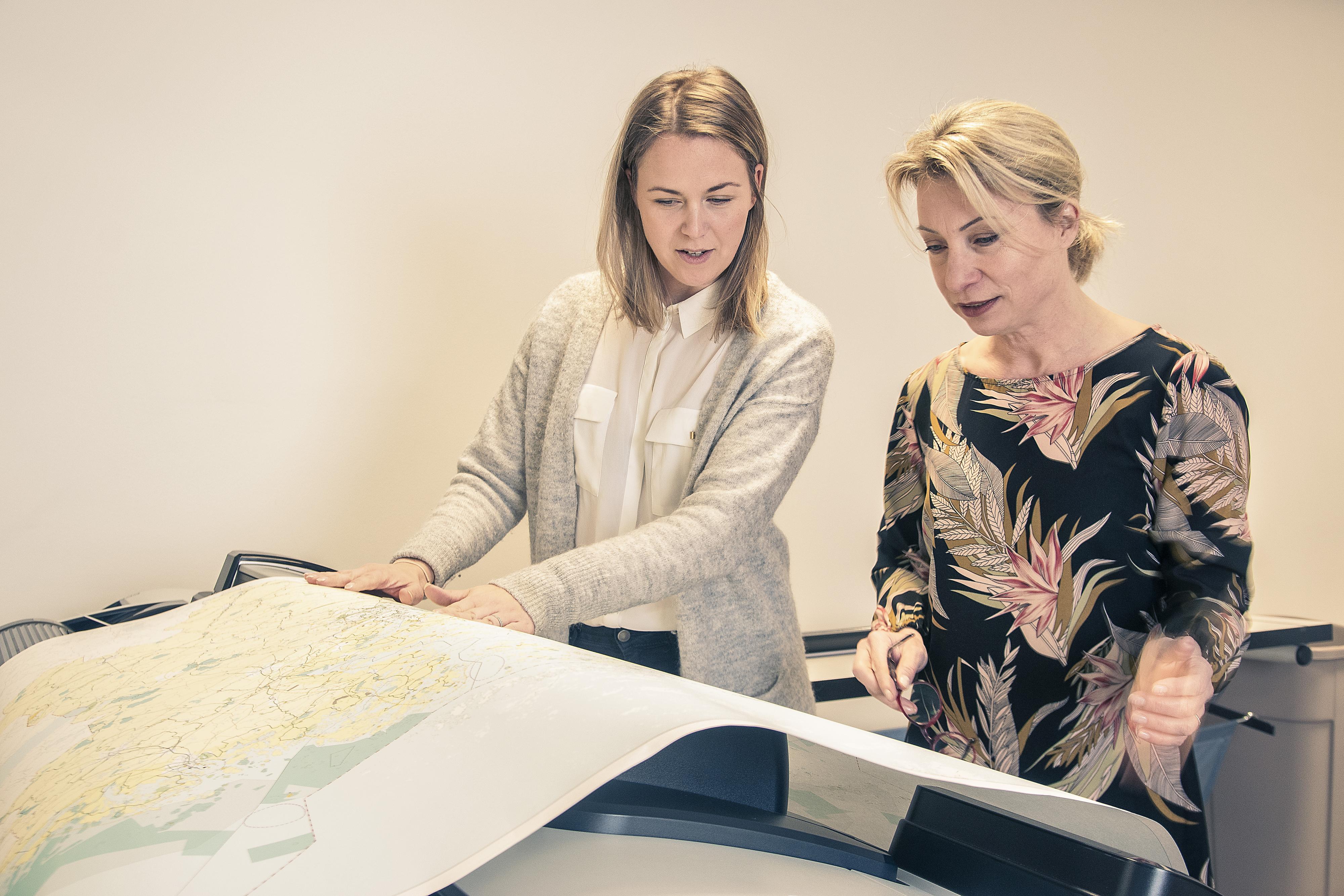 Liiton työntekijät tarkastelevat karttatulostetta yhdessä