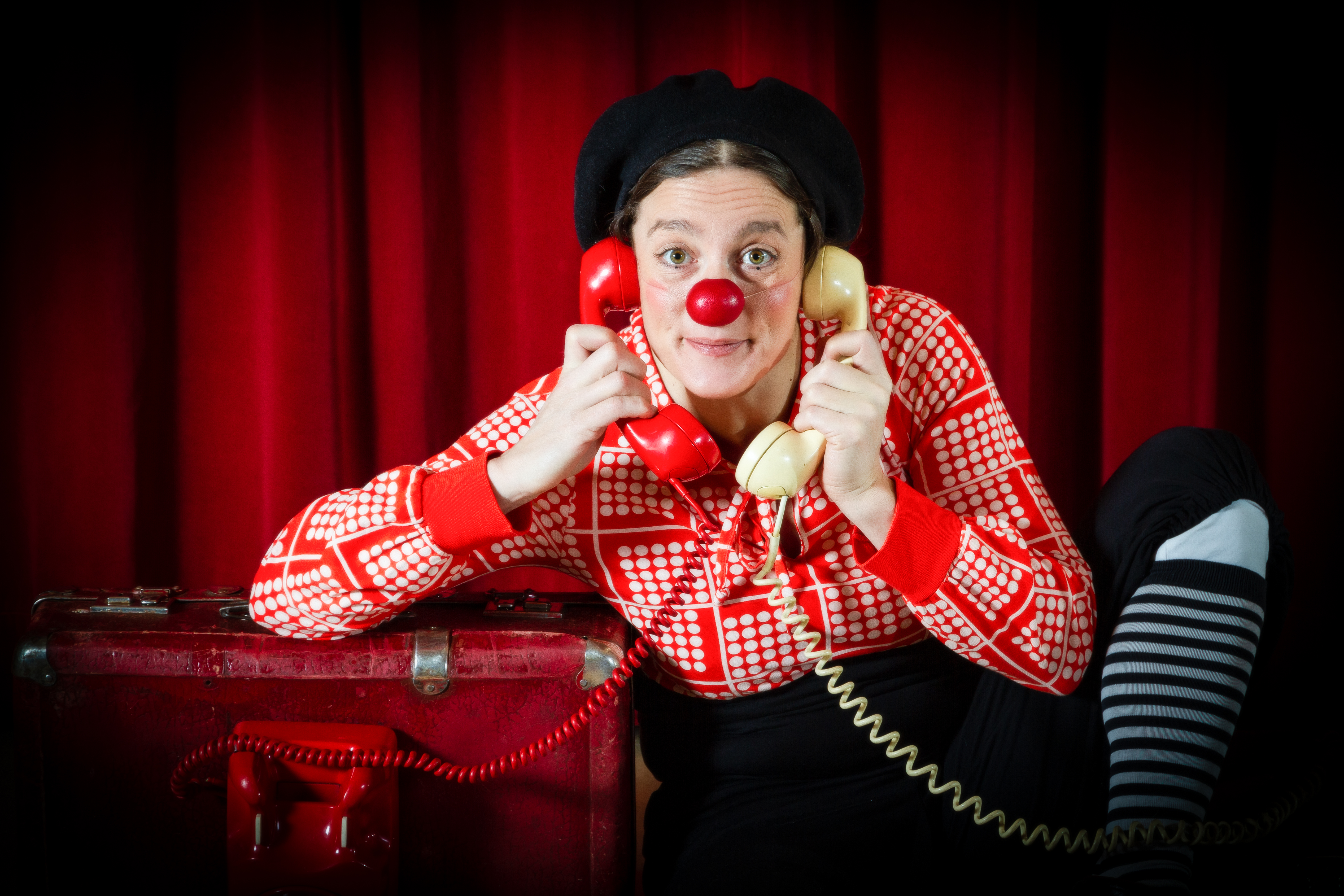 Klovni OHO pitää kahden lankapuhelimen luuria korvillaan.