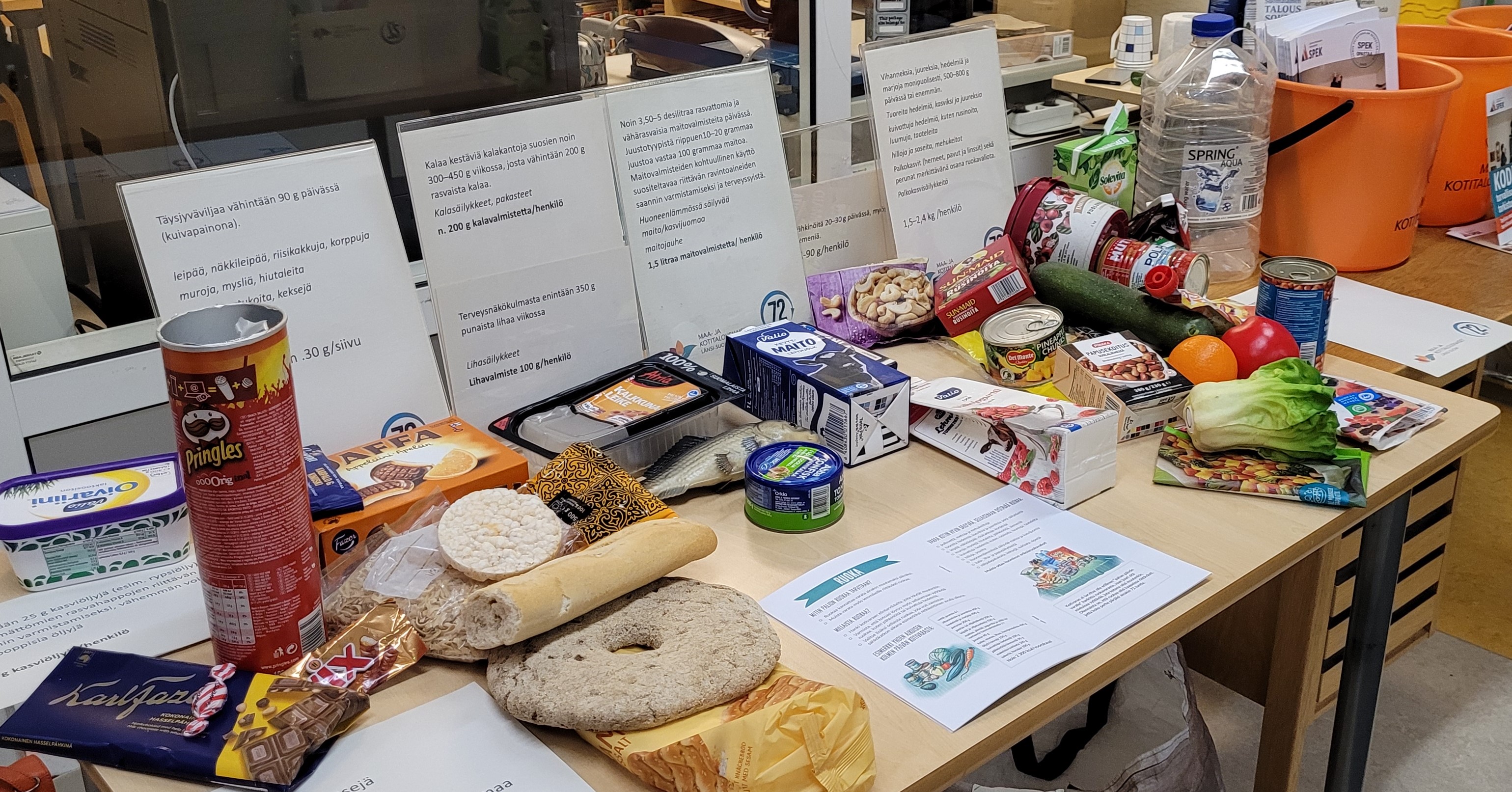 Maa- ja kotitalousnaisten kokoamalla varautumispöydällä on esimerkkejä ruokatarvikkeista, joita pitäisi olla varastossa, jos tulee jokin yhteiskunnallinen häiriötilanne.