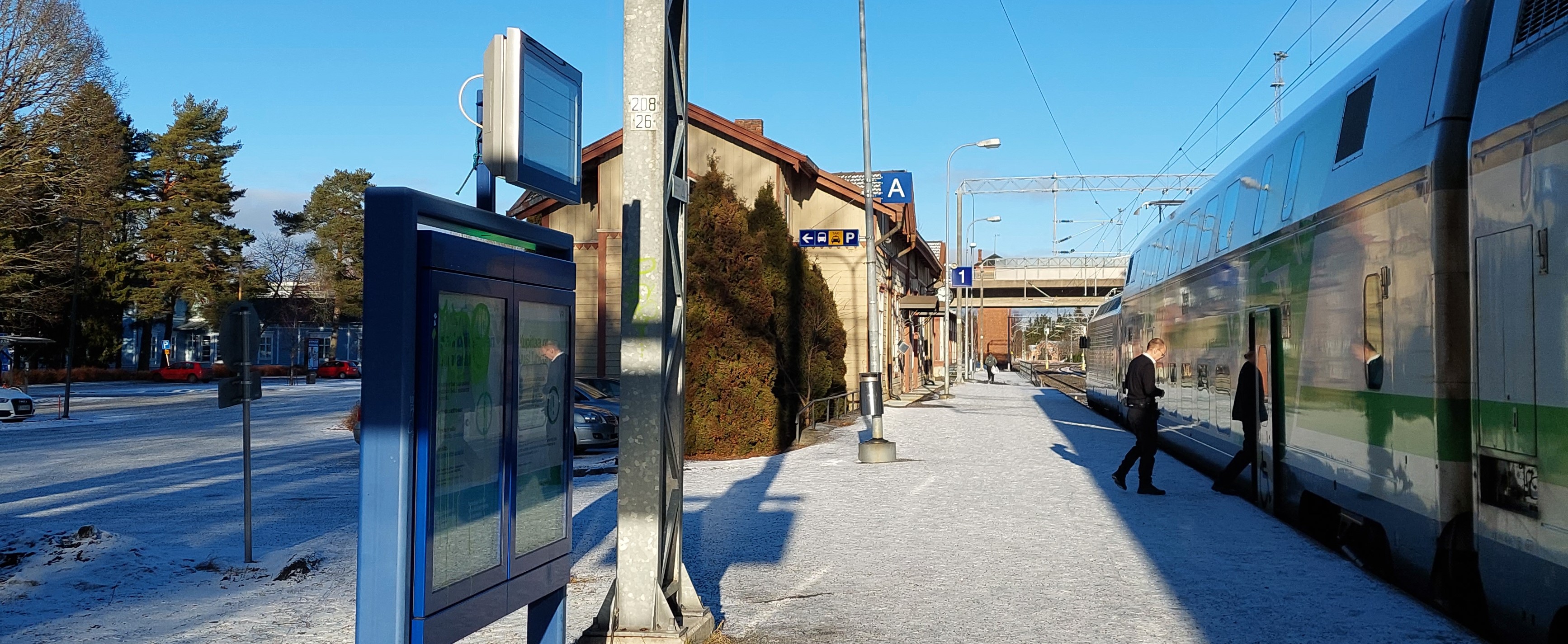 Talvinen Loimaan aseman laituri, juna lähdössä ja ihmisiä astumassa kyytiin