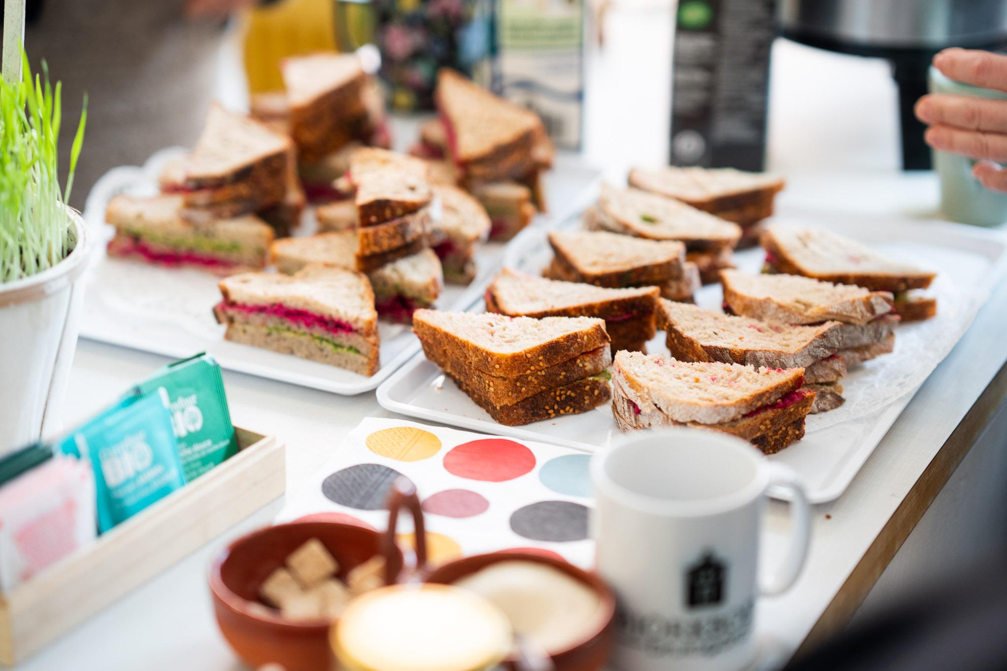 Täytettyjä leipiä ja kuppi pöydällä.