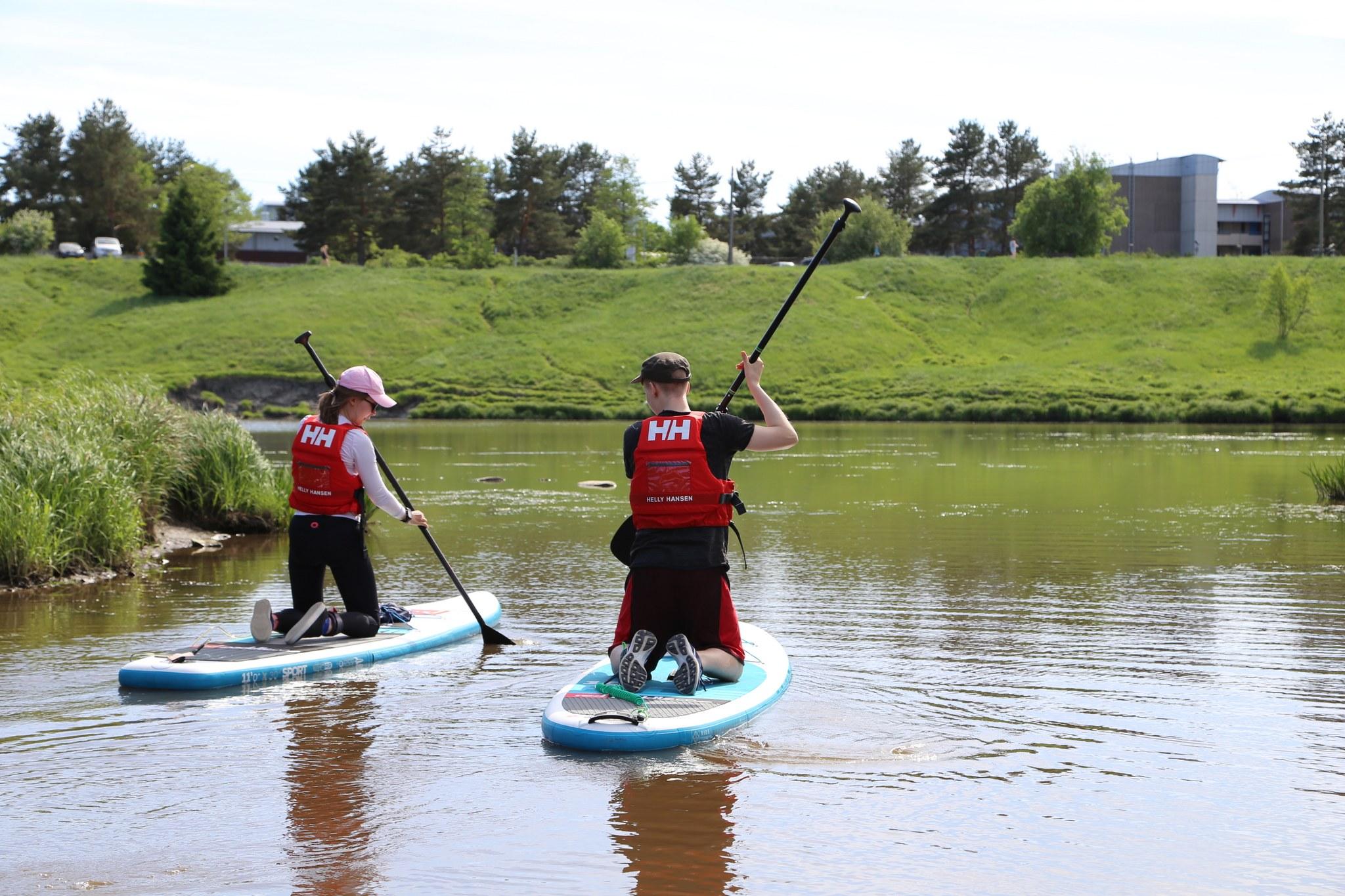 Kaksi sup-lautailijaa Aurajoella.