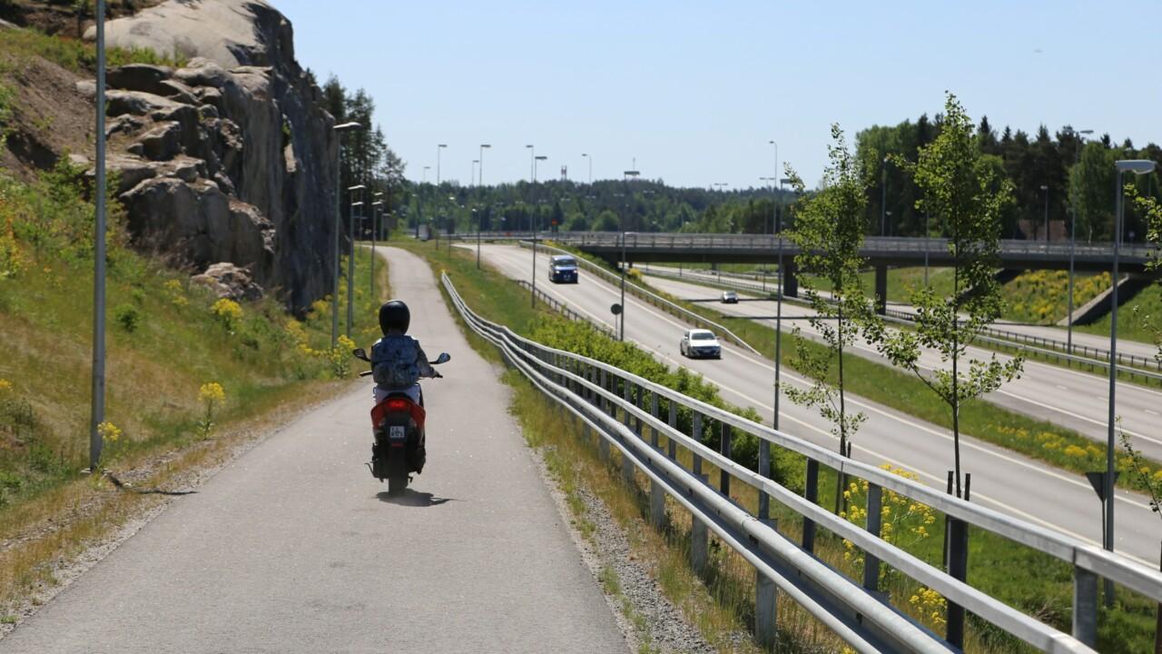 Kevyen liikenteen väylä jossa mopo, vieressä moottoritie