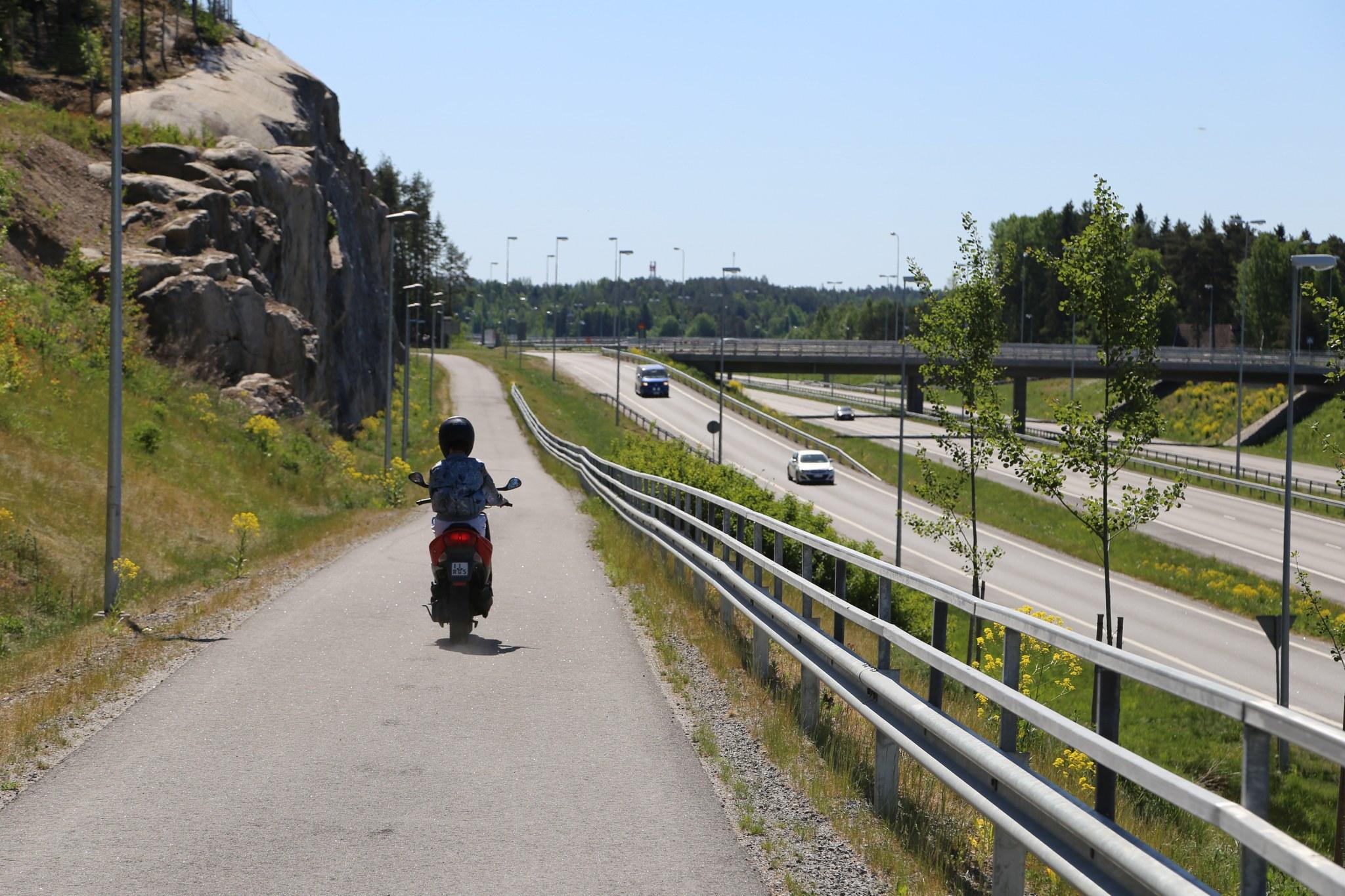 Kevyen liikenteen väylä jossa mopo, vieressä moottoritie